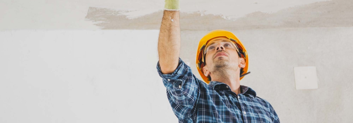 Homme avec casque de construction jaune applicant du plâtre au plafond Plâtrage 5286